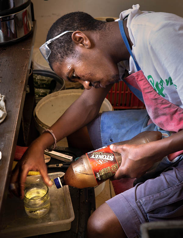 Frank cutting bottles to upcycle at Hillcrest aids centre
